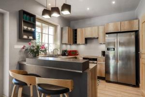 a kitchen with a stainless steel refrigerator and wooden cabinets at Domek nad Potokiem in Nowy Targ