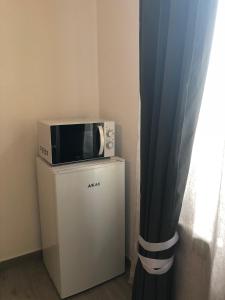 a microwave sitting on top of a refrigerator at Marconi 11 in Bardello +14 photos