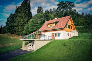 a house with a car parked in front of it at Ferienhaus Almruhe in Schwanberg