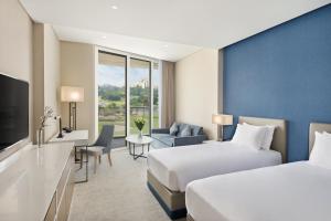 a hotel room with two beds and a television at JA Lake View Hotel, Dubai in Dubai +104 photos