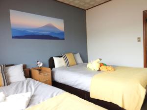 una camera con due letti e un dipinto sul muro di 旭川貸切一軒家プラスティ a Asahikawa