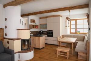 a kitchen and living room with a fireplace and a table at Ferienhaus Almruhe in Schwanberg