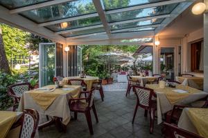 ein Restaurant mit Tischen und Stühlen und einer Glasdecke in der Unterkunft Hotel Adriaco in Grado