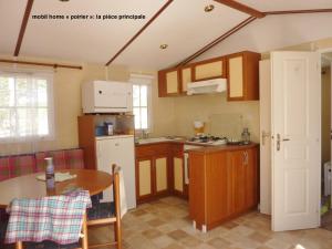 una cocina con armarios de madera y una mesa en una habitación en domaine de Couchenoire en Joux-la-Ville