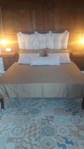 a bedroom with a large bed with white pillows at Villa Alemi' in Rivello