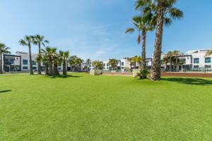 park z palmami i budynkami w tle w obiekcie Oasis Beach F 3003 w mieście Playas de Orihuela