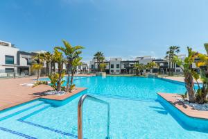duży basen z palmami i budynkami w obiekcie Oasis Beach F 3003 w mieście Playas de Orihuela