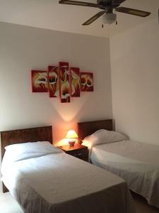 1 dormitorio con 2 camas y ventilador de techo en New and airy apartment in Marsalforn, en Żebbuġ
