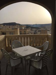 una mesa y sillas en un balcón con vistas en New and airy apartment in Marsalforn, en Żebbuġ