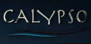 a sign that says alyon on a blue wall at Calypso Patong Hotel in Patong Beach