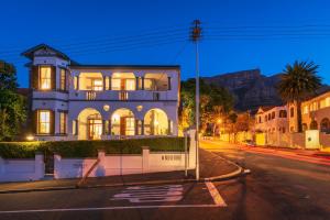 une maison dans une rue avec des montagnes en arrière-plan dans l'établissement Esperanza Guest House, au Cap