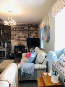 a living room with a couch and a fireplace at The Toll House in Newton Stewart