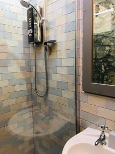 a bathroom with a shower with a phone on the wall at The Toll House in Newton Stewart