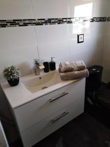 a white bathroom with a sink and a mirror at Ferienwohnung mit kleinem Garten in Sonnenbühl