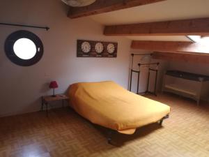sypialnia z żółtym łóżkiem i oknem w obiekcie Appartement Saint Bauzély w mieście Saint-Bauzély