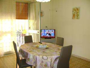 una sala da pranzo con tavolo, sedie e TV di La Camelia a Riposto