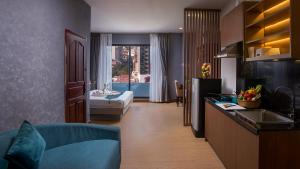 a kitchen and living room with a couch and a sink at Orussey One Boutique in Phnom Penh