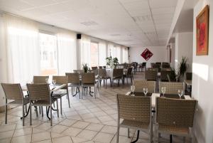 a dining room with tables and chairs and windows at Lodges Méditerranée in Vendres-Plage +55 photos