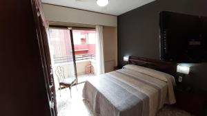 sypialnia z łóżkiem, telewizorem i oknem w obiekcie Alicante & Urban Center w Alicante