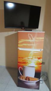 a cup and a plate of cookies and a tv at Giusy's Place 2.0 in Campofelice di Roccella