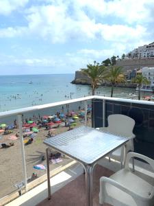 a balcony with a table and chairs and a beach at Hotel Mare Nostrum in Peniscola