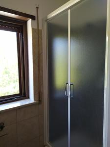 a glass shower door in a bathroom with a window at Casa Ateleta LU.PA. in Ateleta