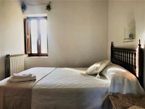 ein Schlafzimmer mit einem großen Bett mit Fenster in der Unterkunft Casa Rural La Escuela in Los Molinos