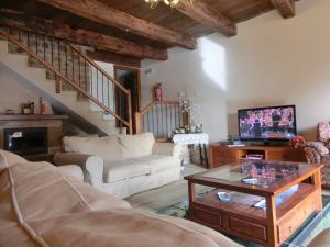 a living room with a couch and a table with a tv at Natura Jordan in Murillo de Gállego