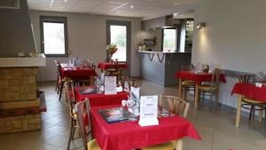 een restaurant met rode tafels en stoelen met rode tafellakens bij Camping de la Pelouse in Jaulny