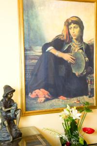 a painting of a woman sitting in front of a painting at Oriental Rivoli Hotel & Spa in Sharm El Sheikh