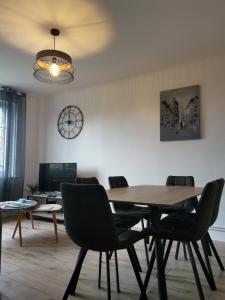 a dining room with a wooden table and chairs at Face aux remparts in Boulogne-sur-Mer