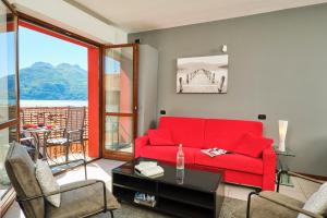 ein Wohnzimmer mit einem roten Sofa und einem Tisch in der Unterkunft Lario View Apartment in Acquaseria