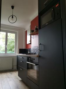 een keuken met een zwarte koelkast en een raam bij Face aux remparts in Boulogne-sur-Mer