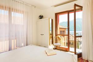 a bedroom with a bed and a large window at Lario View Apartment in Acquaseria