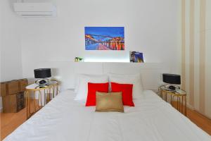 ein Schlafzimmer mit einem weißen Bett mit roten Kissen in der Unterkunft Private House Only For You 133 - 8min historicCenter in Vila Nova de Gaia + 14 Fotos