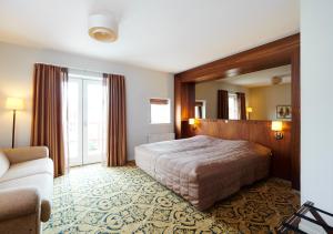 una camera d'albergo con letto e specchio di Montra Odder Parkhotel a Odder