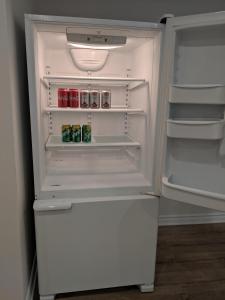 un frigorifero bianco con porta aperta e bevande all'interno di Spacious basement one bedroom apartment, WiFi. a Montréal