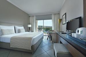 a hotel room with a bed and a television at JAZ Mirabel Resort in Sharm El Sheikh
