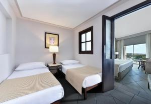 a hotel room with two beds and a balcony at JAZ Mirabel Resort in Sharm El Sheikh