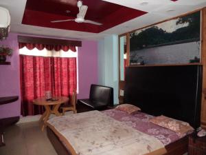 a bedroom with a bed and a chair and a window at Hotel Grace in Shillong