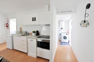 una cucina bianca con lavello e microonde di 137 Private family home -8 min from historic center a Vila Nova de Gaia