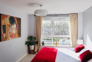 um quarto com uma cama vermelha e uma janela em LuxApartment - Port Of Leith - Free Parking em Edimburgo