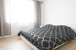 a bedroom with a bed with a black and white comforter at Republiki Korczakowskiej Ferienwohnung in Krakow