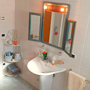 un bagno con un lavandino bianco e uno specchio di Le Vigne di Annalisa Sweet Relax Rooms in Unesco Prosecco D.o.c.g. a Farra di Soligo Altre 36 foto