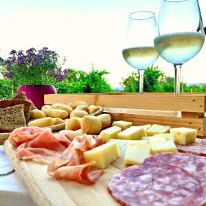 a tray of cheese and meats and glasses of wine at Le Vigne di Annalisa Sweet Relax Rooms in Unesco Prosecco D.o.c.g. in Farra di Soligo