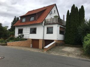 a white house with a red roof at Drei Linden in Osterode in Osterode