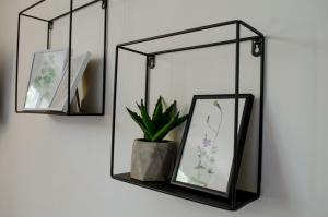 a shelf with two mirrors and a potted plant at Oleander Rooms & Apartment in Sofia