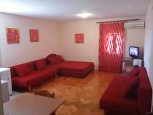 salon z czerwonymi meblami i czerwoną zasłoną w obiekcie Stari Grad Studio Apartment w mieście Herceg Novi