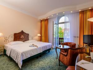 1 dormitorio con cama, mesa y TV en Hotel Palmenhof en Frankfurt