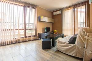a living room with a couch and a desk and windows at Villa Brigantina in Sunny Beach